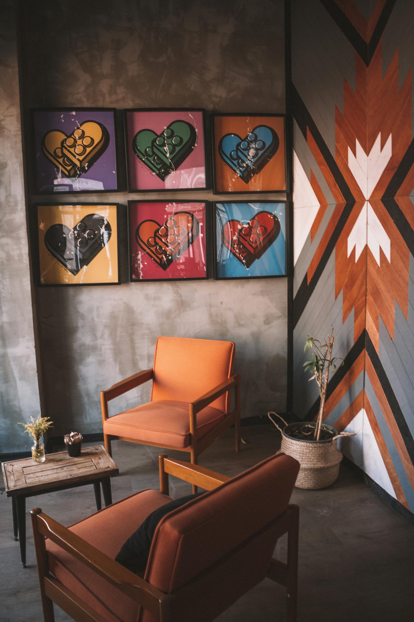 Stylish interior with framed heart artwork and mid-century chairs enhancing modern design.